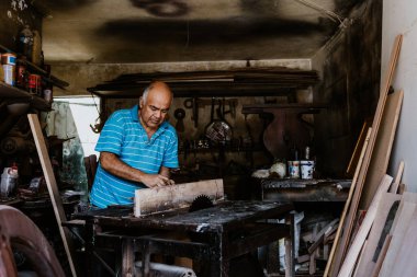 Latin Amerika 'daki mobilya atölyesinde çalışan İspanyol kıdemli marangoz.