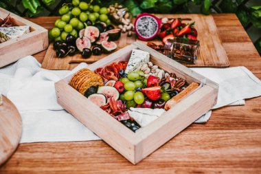 Appetizers table with brie cheese, fruit and snacks. Cheese and meat variety board in Mexico Latin America