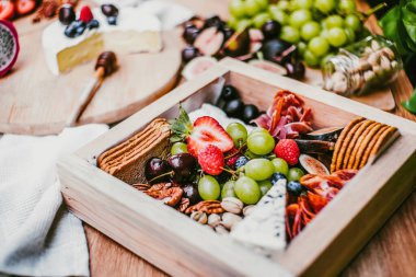 Appetizers table with brie cheese, fruit and snacks. Cheese and meat variety board in Mexico Latin America