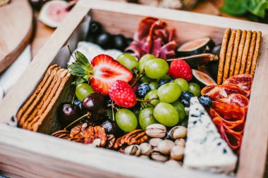 Appetizers table with brie cheese, fruit and snacks. Cheese and meat variety board in Mexico Latin America
