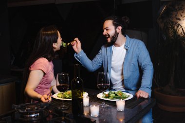Young hispanic couple dining on celebration toasting at home in Mexico Latin America