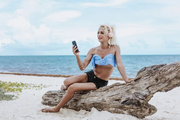 화장을 아메리카의 해변에서 헤드폰 전화로 음악을 트랜스젠더 — 스톡 사진