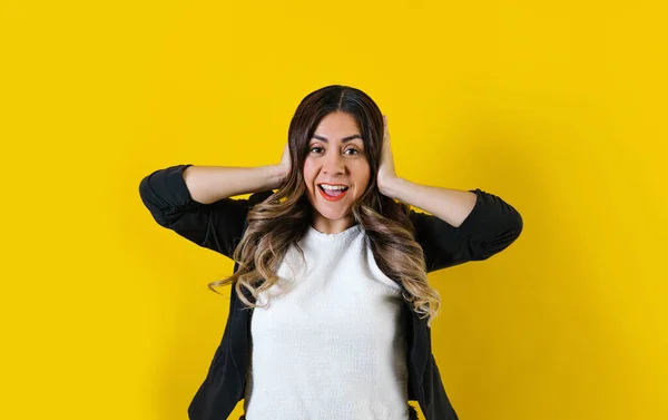 young hispanic business woman with surprise facial expression posing isolated over yellow background in Mexico Latin America