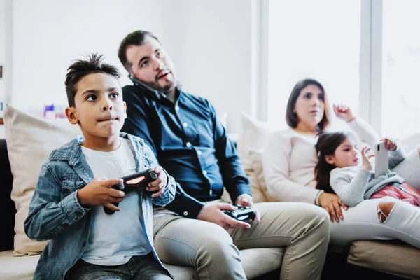 Latin father and his son playing video games and competing with each other at home in Mexico, Hispanic people