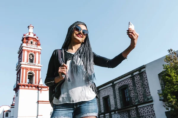 在墨西哥的大街上 一个留着辫子的年轻的拉丁女人用手机给自己照相 他的惊慌失措的人们 — 图库照片
