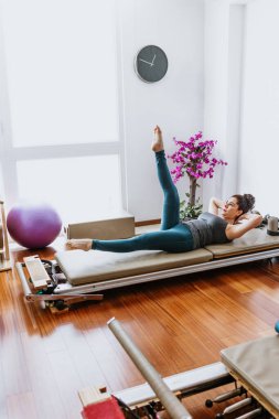 Latin kadın Meksika 'da pilates reformist yatak egzersizleri yapıyor, İspanyol insanlar...