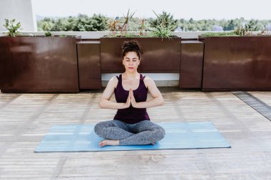 Latin kadın Meksika 'da terasta meditasyon yapıyor, İspanyol insanlar