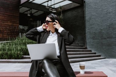 Latin Amerika 'da Mexico City' de dizüstü bilgisayar ve kulaklık kullanan Latin bir iş kadını. Latin bir kadın.