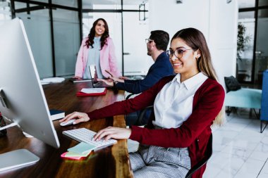 Latin Amerika 'da çalışan ve bilgisayar ya da laptop kullanan genç Latin iş kadını.