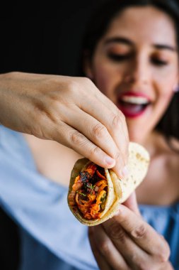 Mexican woman eating tacos al pastor, mexican food in Mexico Latin America clipart