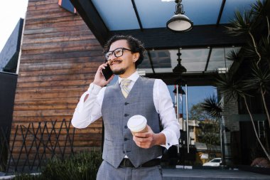 Meksika 'da sokakta cep telefonuyla konuşan genç Latin iş adamı, İspanyol erkek.