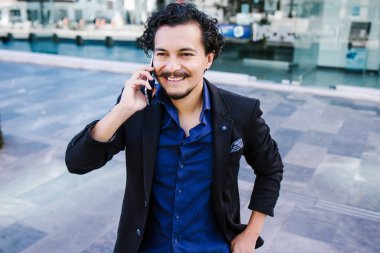 Meksika 'da sokakta cep telefonuyla konuşan genç Latin iş adamı, İspanyol erkek.