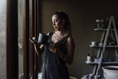 Seramik atölyesinde çalışan ve çömlek üreten genç Latin kadın. Meksika 'da küçük işletme ve girişimcilik Latin Amerika' da Latin kadın