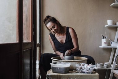 Latin kadın çömlekçinin elleri Meksika 'daki atölyesinde çömlek tekeri üzerinde kilden bir kap yaratıyor. İspanyol kadın.