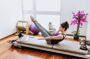 Latin kadın Meksika 'daki evinde ıslahevi yatağında pilates egzersizi yapıyor. İspanyol insanlar.