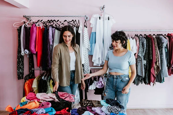 latin woman customer shopping in Clothing Store with saleswomant in Fashionable Shop choosing Stylish Clothes in Mexico Latin America, hispanic people