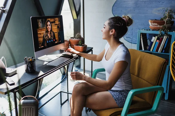 Young latin woman in a video conference call on desk computer at home office in Mexico Latin America