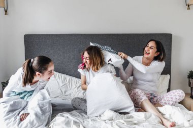 Latin kadınlar, anne ve kız aileleri Latin Amerika 'da yataklarında yastık savaşı yapıyorlar.