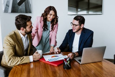 Latin iş adamları ya da Latin Amerika 'daki ofiste laptopla günlük kıyafetlerle çalışan genç takım çalışanları, İspanyol asıllı insanlar.