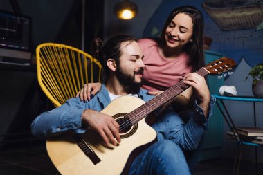 Romantik bir buluşmada gitar çalan genç Latin bir çift, kız arkadaş ve erkek arkadaş Meksika 'da gece evde eğleniyorlar, Latin Amerikalılar.