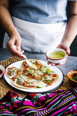 Meksikalı kadın, Meksika Latin Amerika 'da taco hazırlıyor ve geleneksel Meksika yemekleri yiyor.