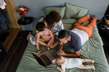 Latin ve çocuklu bir aile Meksika 'da, Latin Amerika' da, yatakta birlikte eğleniyorlar.