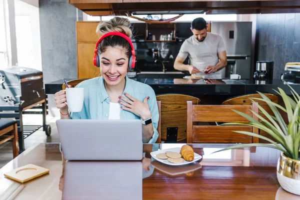 young latin woman using laptop and headphones at home in Mexico, hispanic student people in home office Latin America