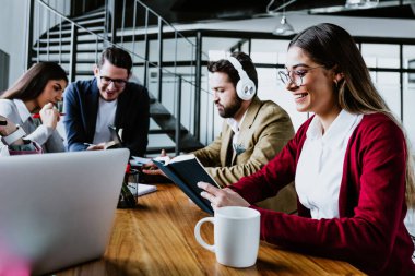 Latin Amerika 'daki ofiste bilgisayar ya da dizüstü bilgisayar kullanan genç Latin iş kadını Latin takım çalışması yapıyor.