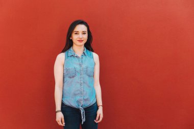 Latin Amerika 'da genç Latin kadın portresi, kırmızı arka planda İspanyol kadın.