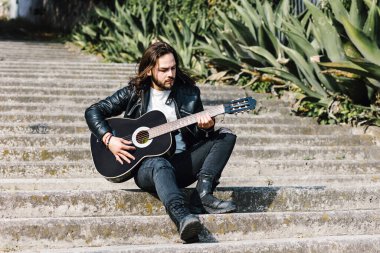 Rock 'n Roll tarzındaki genç Latin adam Meksika' da sokakta gitar çalıyor, Latin Amerika 'da, Latin insanlar