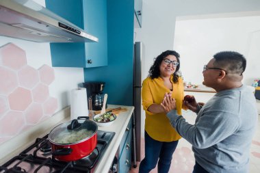 Latin lezbiyen çift Meksika 'da mutfakta yemek pişiriyor. Latin Amerika' da gökkuşağı bayrağı taşıyan, LGBT topluluğundan homoseksüel İspanyol insanlar.