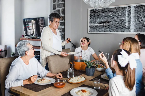 latin family of multi generational women eating together at home in Mexico Latin America, hispanic people