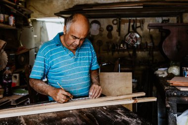 Latin kıdemli marangoz portresi. Meksika Latin Amerika 'da mobilya marangozluğu atölyesinde ahşap işçiliği yapıyor. 