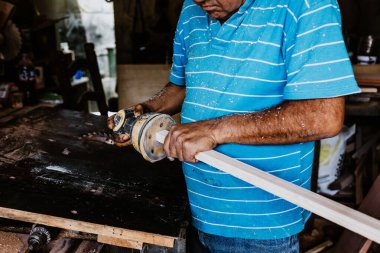 Latin kıdemli marangoz Meksika Latin Amerika 'daki marangozluk atölyesinde zımpara kağıdı kullanıyor ve çalışıyor.
