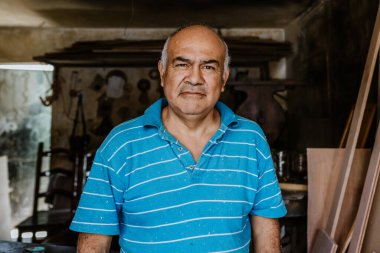 Latin kıdemli marangoz portresi. Meksika Latin Amerika 'da mobilya marangozluğu atölyesinde ahşap işçiliği yapıyor. 