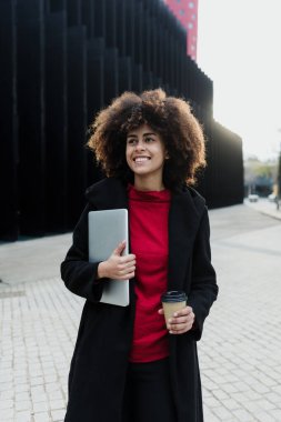 Latin Amerika 'da dizüstü bilgisayar tutan genç Afrikalı Amerikalı iş kadını, İspanyol finans ve Karayipliler 