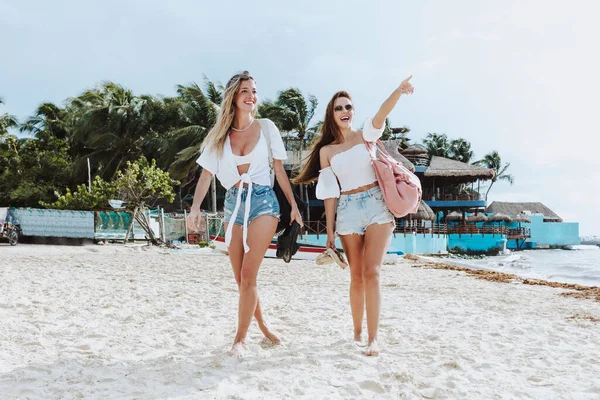 young couple of latin women strolling around the caribbean beach in Mexico Latin America, hispanic female