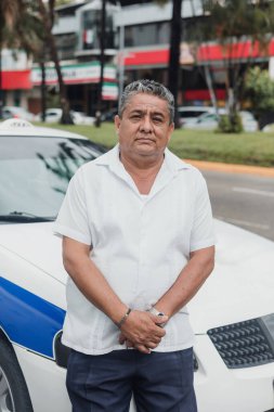 Latin Amerika 'da Mexico' da şehir sokağında arka planda arabası olan Latin taksi şoförü kıdemli bir adamın portresi. Latin yetişkin insanlar.