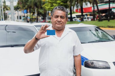 Latin Amerika 'da Latin taksi şoförünün portresi, Latin Amerika' daki şehir sokağında arka planda arabası olan boş bir kart tutuyor. Latin yetişkin insanlar.