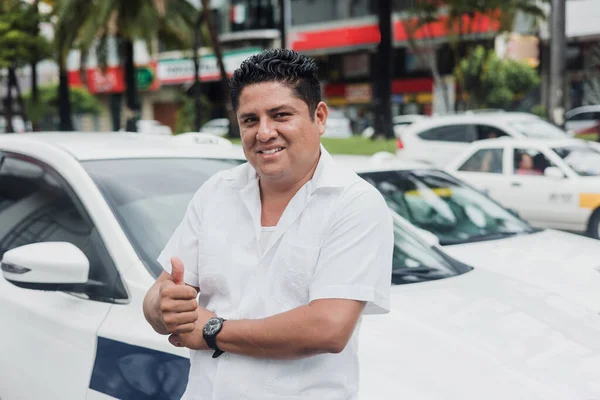 portrait of latin taxi driver man with car on background at city street in Mexico in Latin America, Hispanic people