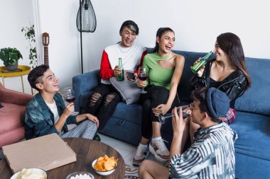 Bir grup Latin LGBT arkadaşı pizza yiyor, içiyor ve Meksika 'da evde eğleniyorlar, Latin Amerika' da Latin homoseksüel ve lgbtq toplulukları partide.