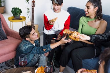 Bir grup Latin LGBT arkadaşı pizza yiyor, içiyor ve Meksika 'da evde eğleniyorlar, Latin Amerika' da Latin homoseksüel ve lgbtq toplulukları partide.