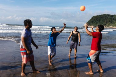 Plajda voleybol oynayan mutlu Latin arkadaşlar Acapulco 'daki Pasifik Okyanusu' nda Latin Amerikalılar, Latin Amerikalılar