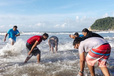 Plaj partisindeki mutlu Latin arkadaşlar Acapulco 'daki Pasifik Okyanusu' na atlıyorlar. Latin Amerika 'daki Latin Amerikalılar.