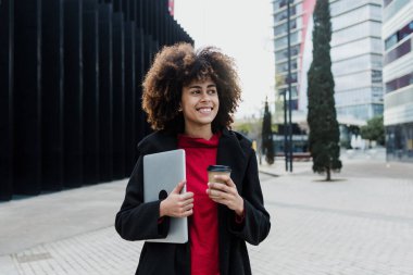 Latin Amerika 'da dizüstü bilgisayar tutan genç Afrikalı Amerikalı iş kadını, İspanyol finans ve Karayipliler 