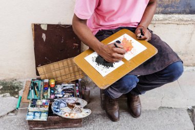 Latin Amerika 'da, Afro Karayip erkek sokak sanatı çizen sokak ressamı veya ressamı.