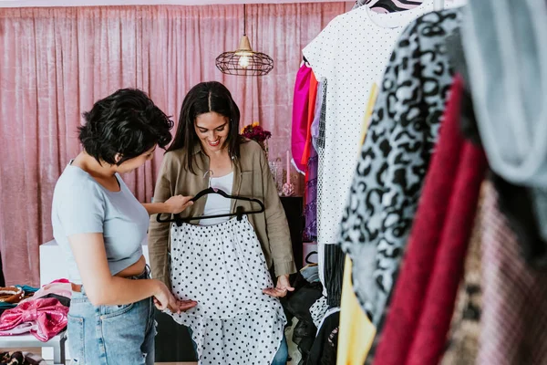 latin woman customer shopping in Clothing Store with sales woman in Fashionable Shop choosing Stylish Clothes in Mexico Latin America, Hispanic small business owner female
