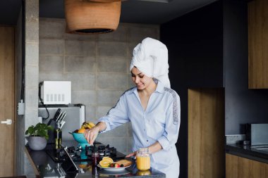Sabahları bornozlu genç bir kadın Meksika 'da mutfakta kahvaltı yapıyor. Latin Amerika' da Latin bir kadın.