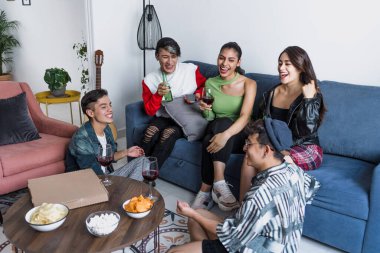 Bir grup Latin LGBT arkadaşı pizza yiyor, içiyor ve Meksika 'da evde eğleniyorlar, Latin Amerika' da Latin homoseksüel ve lgbtq toplulukları partide.