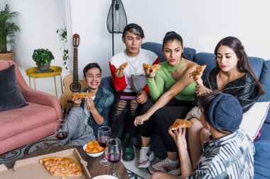 Bir grup Latin LGBT arkadaşı pizza yiyor, içiyor ve Meksika 'da evde eğleniyorlar, Latin Amerika' da Latin homoseksüel ve lgbtq toplulukları partide.